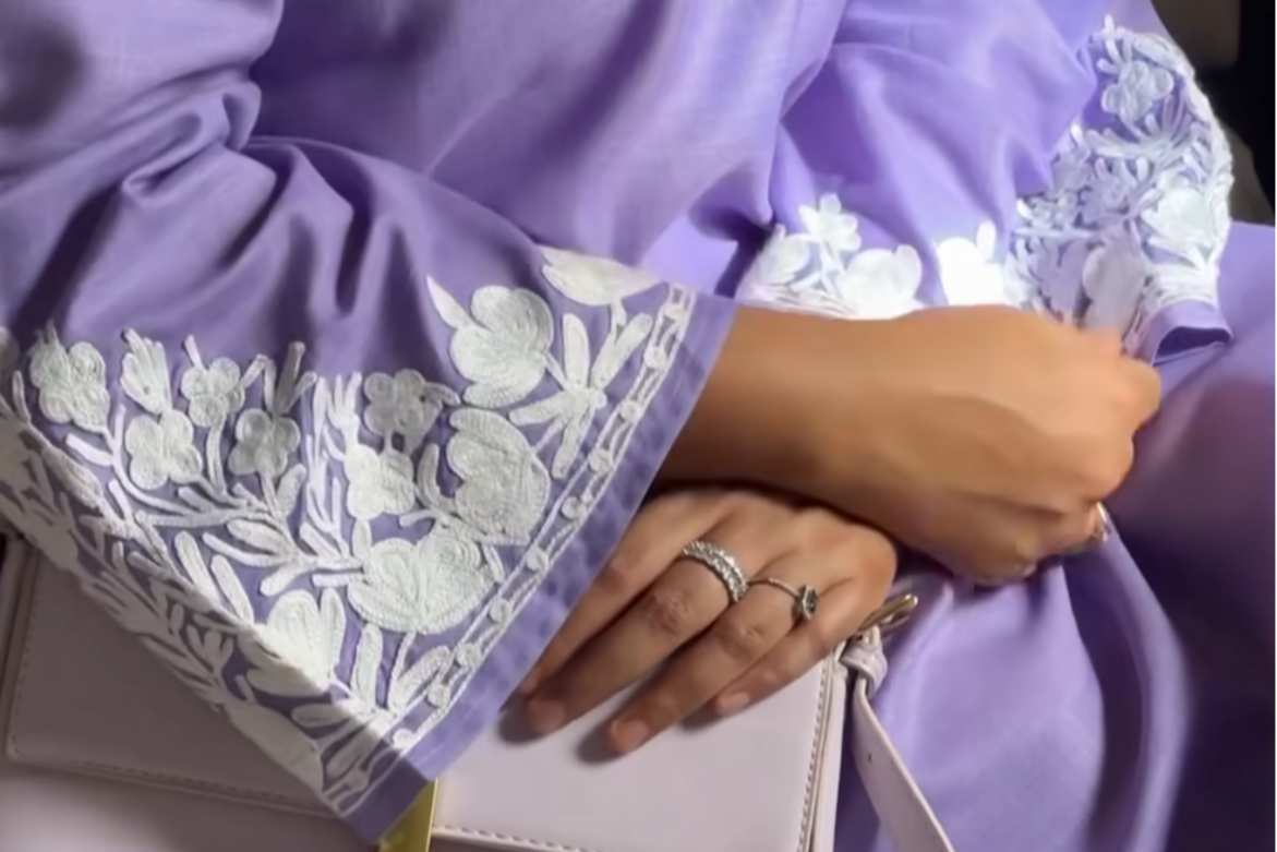 Close-up of neckline embroidery on Huzam – detailed white threadwork on soft lavender fabric