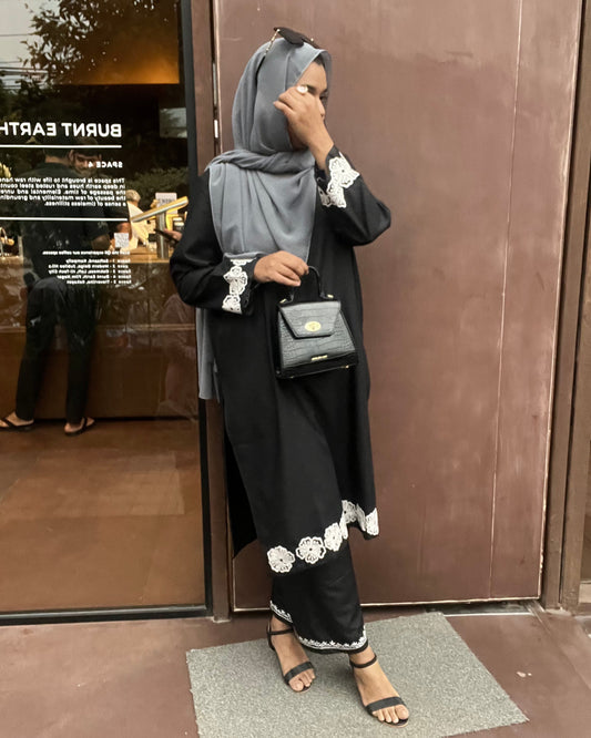 Model wearing Vignette – black embroidered suit set with white thread detailing, full front view