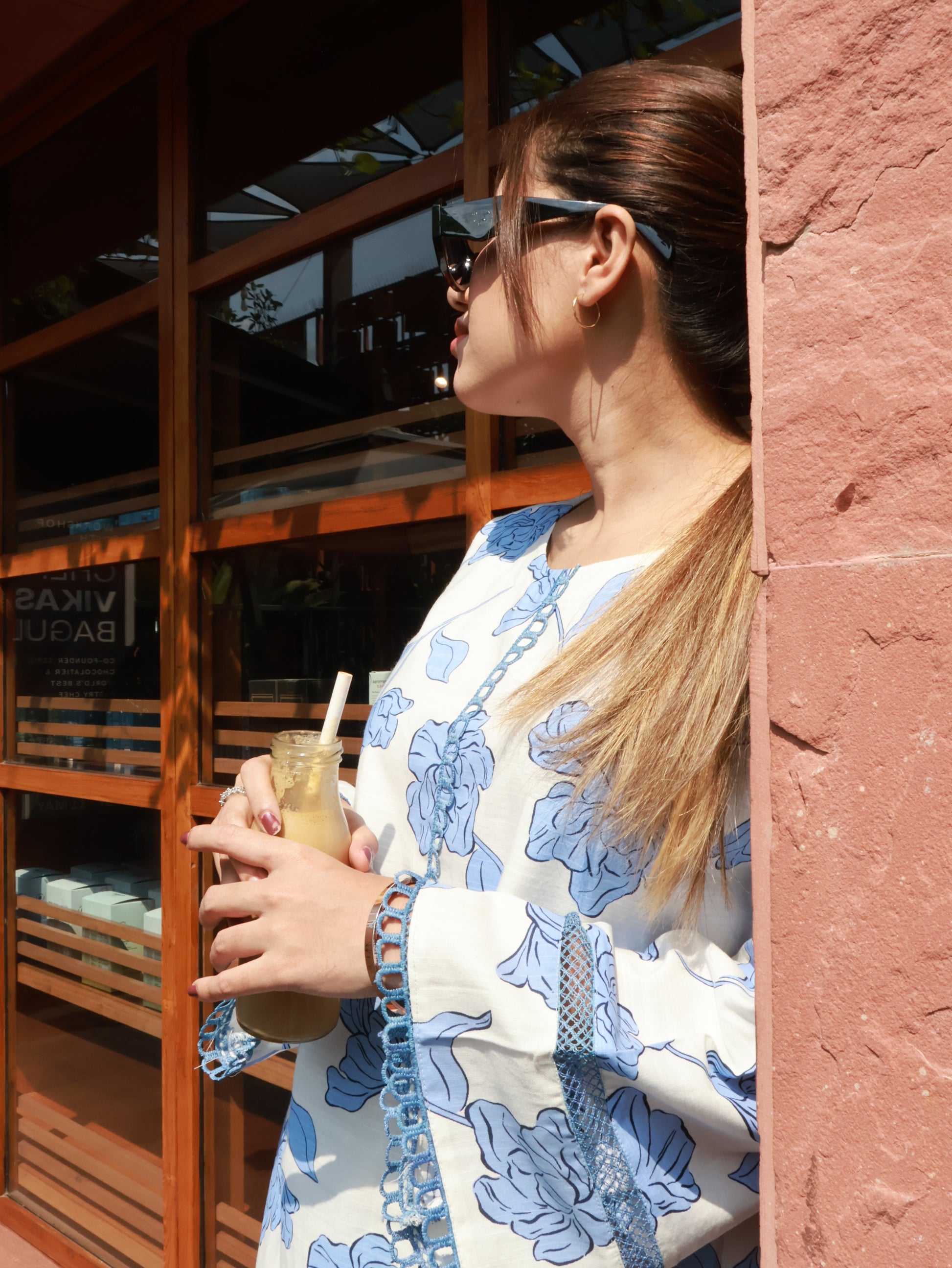 Portrait crop of model with sunglasses, focusing on the kurta’s textile print and lace‑detailed cuff.