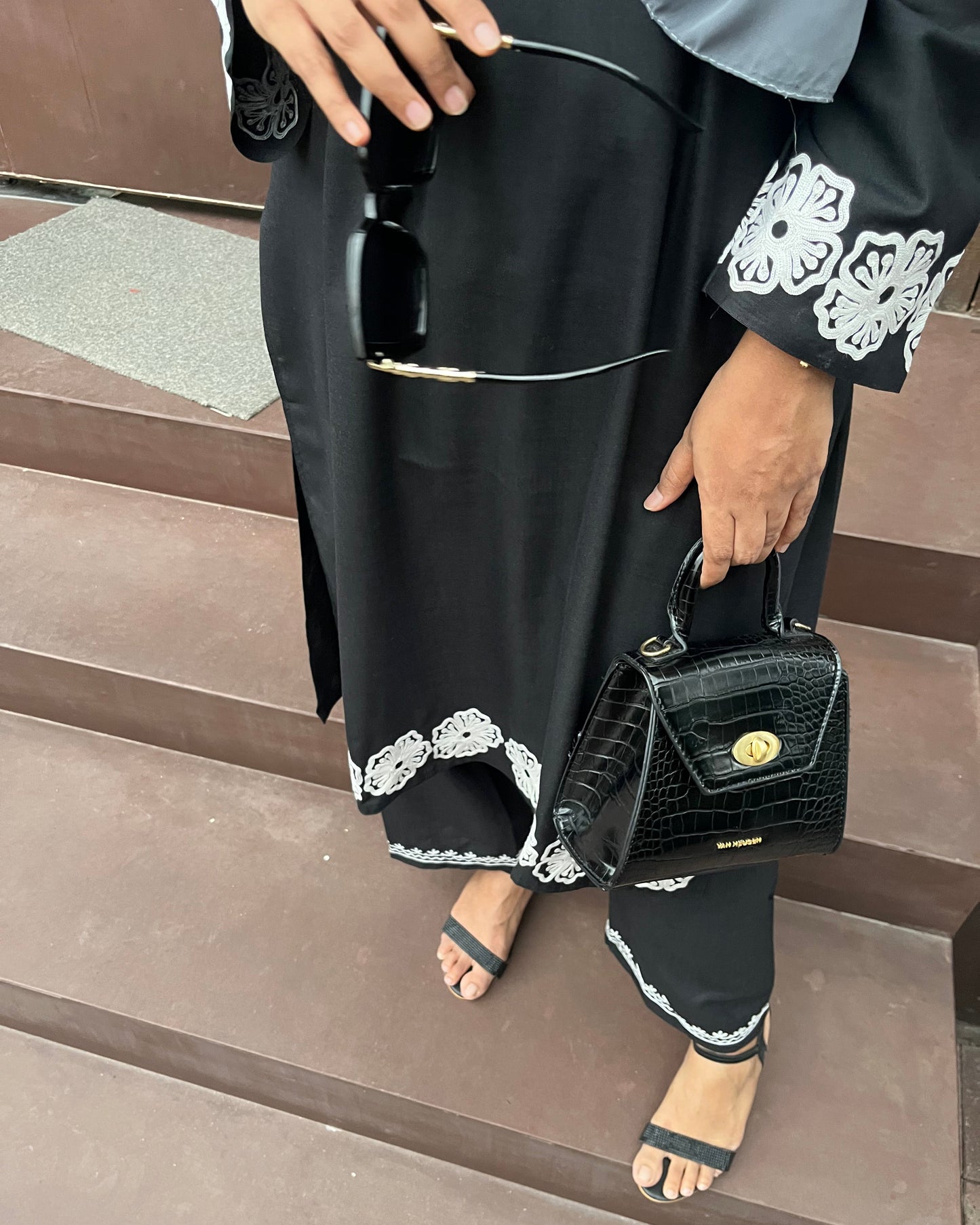 Detailed view of white embroidery on black fabric from BEGUM’S Vignette suit set